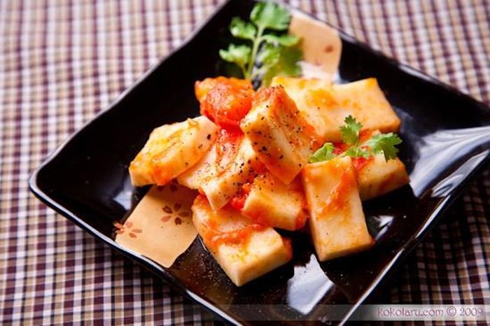 Bạn cho 1 thìa dầu vào chảo rồi phi thơm hành cùng với cà chua, khi cà chua nhừ thì bạn cho một ít nước mắm, hạt nêm vào đảo đều rồi cho dừa vào om cùng. Bạn đun lửa nhỏ cho tới khi nước cạn gần hết, miếng dừa ngấm đều với gia vị là được, rồi trộn ớt và hành tươi vào bắc xuống, cho ra đĩa. Ảnh: kokotaru.com.