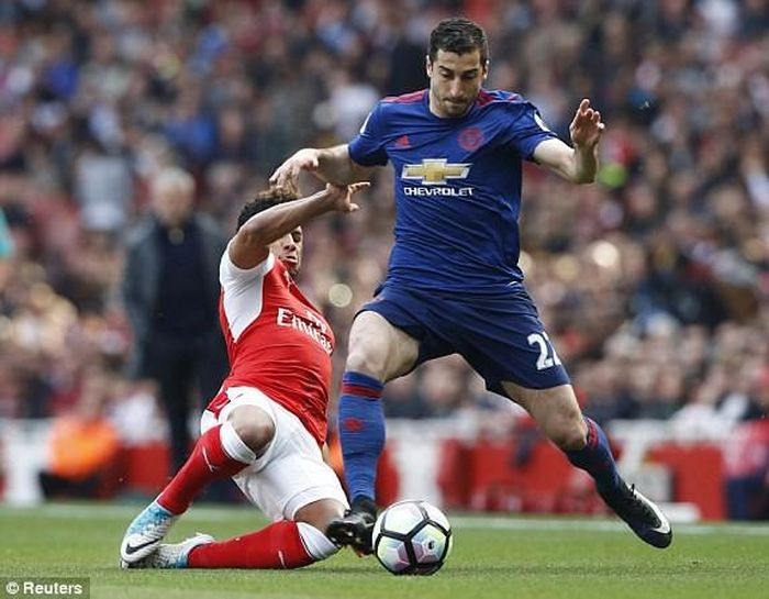 Henrikh Mkhitaryan của M.U đi bóng trong sự truy cản quyết liệt của cầu thủ Arsenal. 
