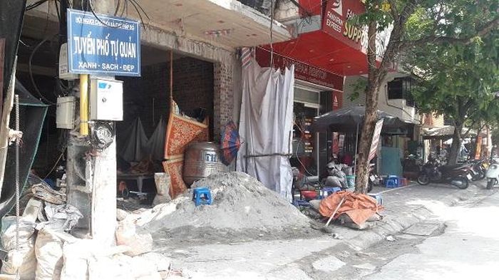  Một công trình xây dựng thản nhiên bày vật liệu xây dựng lấn chiếm vỉa hè. Điều đáng nói, những vi phạm này cách trụ sở Công an phường Văn Miếu không xa.