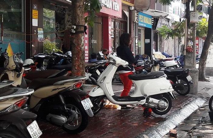 Đoạn qua số nhà 24 phố Quốc Tử Giám, lòng đường, vỉa hè bị biến thành nơi rửa xe máy.