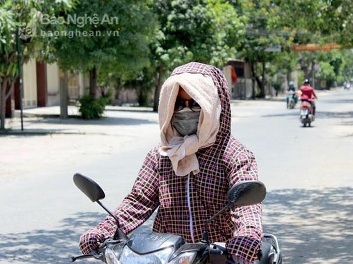 Thời trang chống nóng của người dân "có vẻ" giống nhau khi mỗi người đều bịt kín để chống nóng. Mùa này, các vật dụng, thời trang chống nóng luôn đắt khách. Ảnh: Phương Thúy