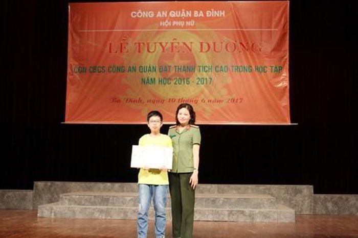 Thượng tá Vũ Thị Kim Yến, Chủ tịch Hội phụ nữ CATP Hà Nội tặng quà cho cháu Đào Minh Quang, học sinh lớp 6 đạt giải Ba trong cuộc thi sáng tạo thanh thiếu niên nhi đồng toàn quốc