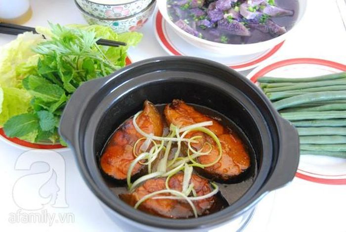 Xếp lát cá thu đã tẩm ướp vào nồi đất, rưới một lớp nước màu và nước ướp cá lên bề mặt. Đun với lửa nhỏ liu riu. Dở đều 2 mặt cá để cá chín đều. Đun tiếp trên lửa nhỏ đến khi thấy thịt cá săn lại thì thêm chút nước vào. Đậy nắp vung, đun đến khi thấy nước trong nồi gần cạn thì tắt lửa. Ảnh: aFamily.vn.