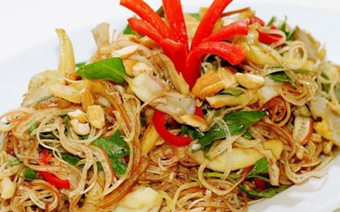 Cho bắp chuối, hành tím, ớt chuông vàng và đỏ, cần tây, ớt sợi, đậu hũ ky vào tô, rưới nước mắm vào trộn đều cho thấm gia vị, thêm hạt điều vào trộn. Ảnh: cacmonchayngon.net.