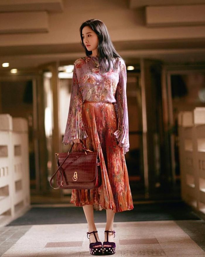 Cô duyên dáng khi mix sơ mi và chân váy xếp li họa tiết ấn tượng. 