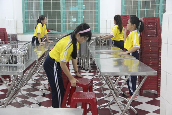  Học sinh lớp 5 hỗ trợ việc chuẩn bị bàn, ghế cho bữa trưa