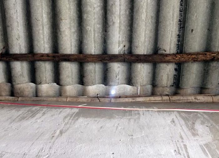Mái nhà lợp bằng tấm fibro xi măng bị đạn xuyên thủng một lỗ nhỏ bằng ngón tay. Ảnh: Hoàng Cư.