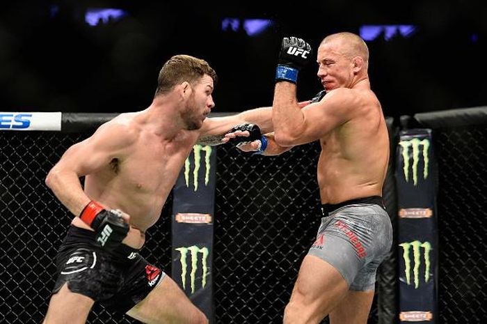 Trong trận đấu chính của sự kiện, sau 4 năm, huyền thoại UFC Georges "GSP" St-Pierre (phải) đã thượng đài trở lại trong trận tranh đai với nhà vô địch hạng trung Michael Bisping. 