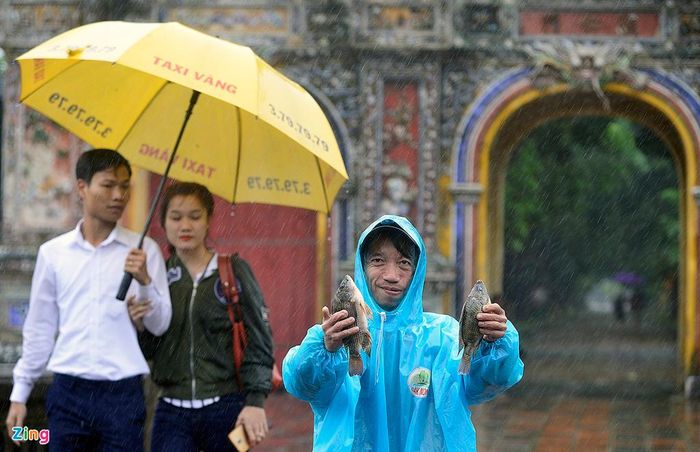Người đàn ông tên Thịnh khoe chỉ trong vài phút bắt được hai con cá rô phi ngay phía cổng Hiển Nhơn nằm ở phía đông của kinh thành Huế, trên đường Đoàn Thị Điểm.