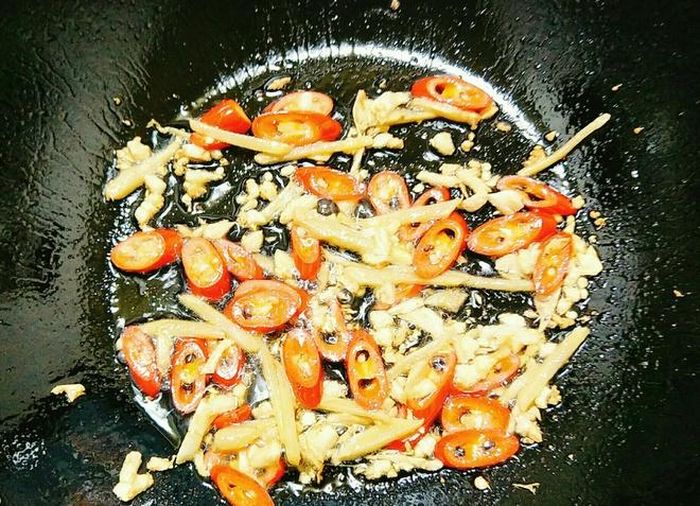 Đặt chảo lên bếp cùng với 2 thìa dầu ăn, bạn đợi đến khi dầu nóng thì cho tỏi băm, gừng thái sợi và phi cho thơm rồi cho ớt sừng vào xào. 