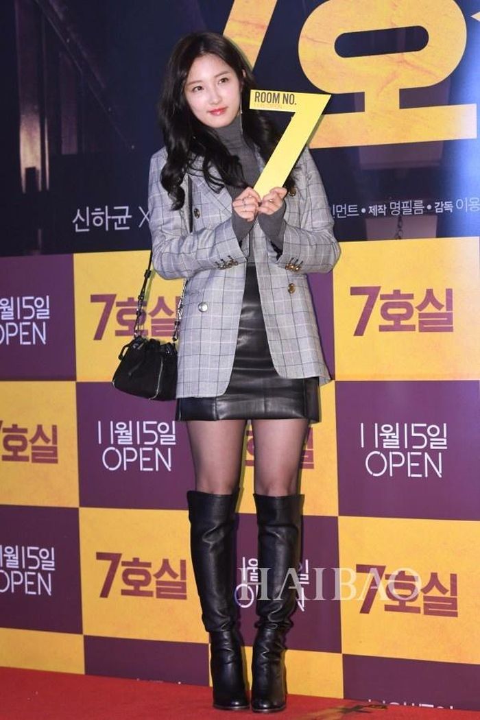 Nam Ji Hyun phối blazer kẻ cùng áo len xám, chân váy da và bốt cao quá gối. 