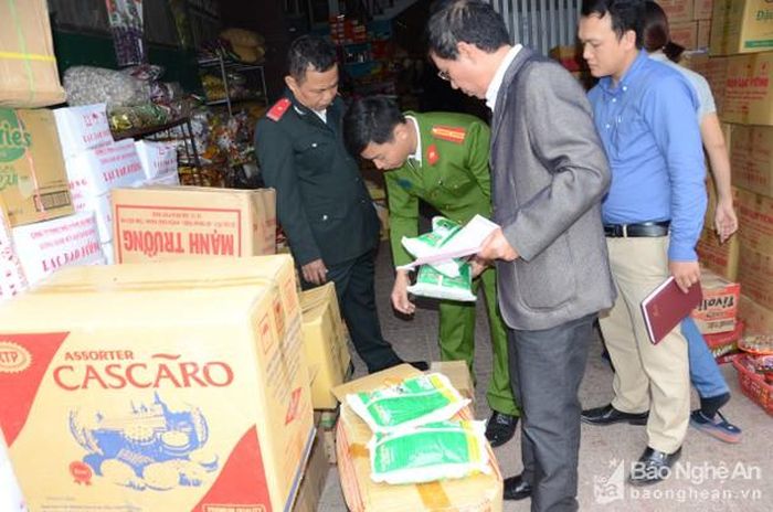 Đoàn liên ngành kiểm tra tại một quầy hàng bánh kẹo ở chợ Vinh. Ảnh: Thanh Sơn