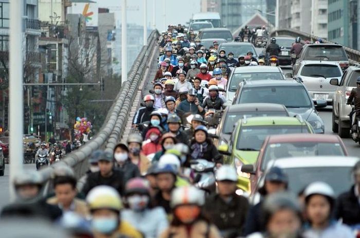  Nhiều người dân phớt lờ biển cấm, thản nhiên điều khiển xe máy đi lên cầu trong giờ cao điểm. Ảnh: Trần Anh. 