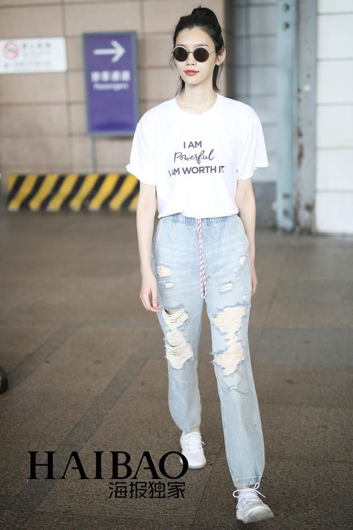 Cũng mix áo thun in chữ với quần jeans, Hề Mộng Dao thoải mái hơn với kiểu quần boyfriend rách gối cá tính. Siêu mẫu nổi tiếng thu hút người đối diện với làn da trắng sáng, tóc buộc nửa trẻ trung.