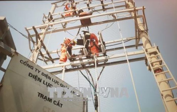 Công nhân Công ty Điện lực Quảng Ninh khắc phục sự cố sét đánh hỏng đường dây truyền tải điện 22kV khiến toàn bộ đảo huyện đảo Cô Tô mất điện. (Ảnh: Văn Đức/TTXVN)