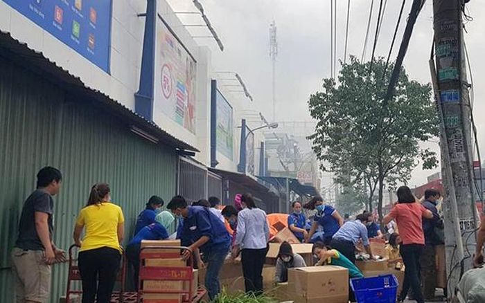 Nhân viên siêu thị dọn hàng hóa ra ngoài. 