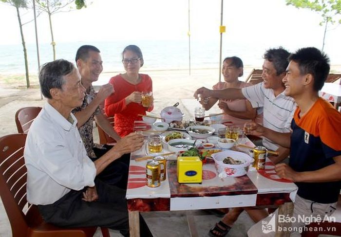 Khách du lịch thưởng thức hải sản tại biển Cửa Lò. Ảnh: Quang An