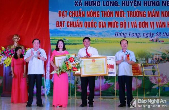 Lãnh đạo huyện Hưng Nguyên trao Bằng công nhận đạt chuẩn Quốc gia và Danh hiệu Đơn vị văn hóa cho Trường Mầm non xã Hưng Long. Ảnh: Nguyễn Hải