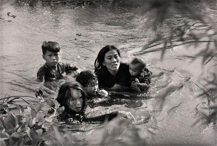  14. Chiến Tranh ở Việt Nam: Tháng 9/1965. Bình Định. Người mẹ và bọn trẻ vượt sông, thoát khỏi lửa đạn. Tác giả Kyoichi Savada.