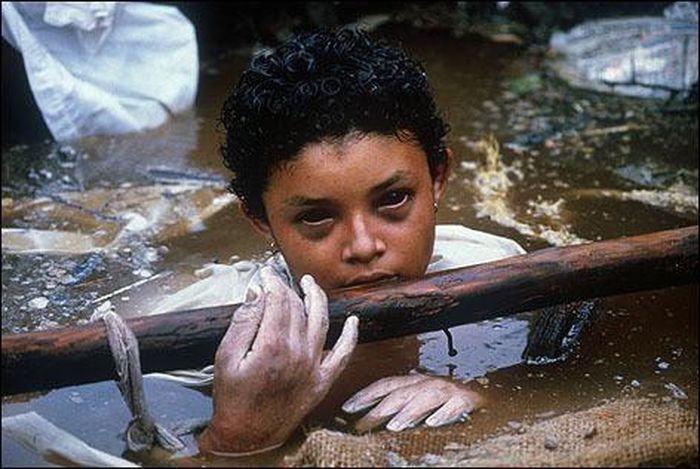  9. Omayra Sánchez - 1985: Đôi mắt đã ám ảnh người xem này là của cô gái 13 tuổi Omaya Sánchez trong thảm họa núi lửa Nevado del Ruiz ở Colombia ngày 13 tháng 11 năm 1985, đã giết chết 25 ngàn người. Trong ảnh, Omaya đã kiệt sức vì bị mắc kẹt gần 3 ngày đêm trước sự bất lực của lực lượng cứu hộ. Cuối cùng, mọi người đã ở bên cạnh em và cùng cầu nguyện đến khi em không còn cầm cự được sau 60 giờ. Bứa ảnh được chụp bởi Frank Fournier.