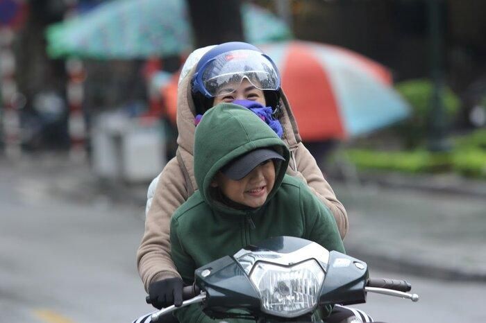 Ra đường ngày mưa rét, cậu bé vẫn cười thật tươi.