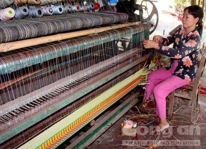 Bà Thủy ngồi dệt chiếu để duy trì cuộc sống gia đình.