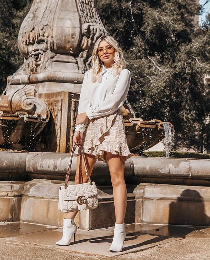 Sơ mi lụa đi cùng chân váy vải tweed, thêm vào đó là phụ kiện đồng điệu sắc trắng sẽ mang lại tổng thể ưa nhìn cho các nàng công sở.