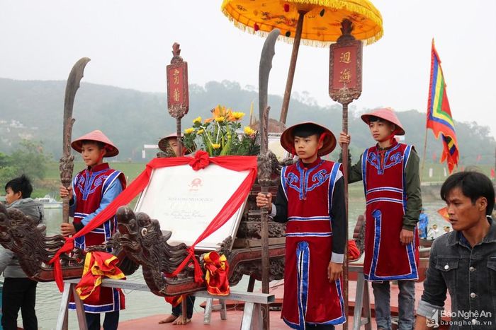 Sau khi đoàn rước bộ xuống một đoàn thuyền lớn, đoàn rước ngược sông Lam tiến về cầu Yên Xuân để làm lễ. Trong ảnh: Kiệu rước Bằng Di tích lịch sử Quốc gia đền Thanh Liệt được đặt trang trọng trên thuyền dẫn đầu.