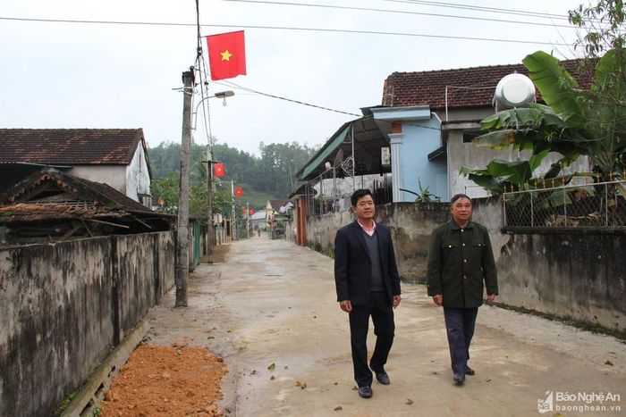 Cán bộ xã Khai Sơn, huyện Anh Sơn (trái) trao đổi với Bí thư kiêm Xóm trưởng xóm 4 về xây dựng đường giao thông nông thôn. Ảnh tư liệu