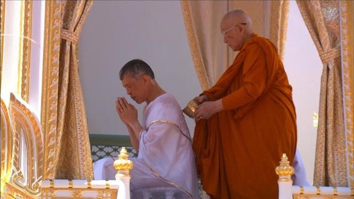 Vua Vajiralongkorn, mặc áo choàng trắng, trải qua nghi thức thanh tẩy trong trước khi chính thức đăng quang tại Bangkok. Trước nghi thức đăng quang, ông phải trải qua nghi thức thanh tẩy dưới một đài phun nước thánh. Những hòa thượng trưởng lão lần lượt tưới nước thiêng lên nhà vua, sau đó là các linh mục Bà la môn và các thành viên hoàng tộc.