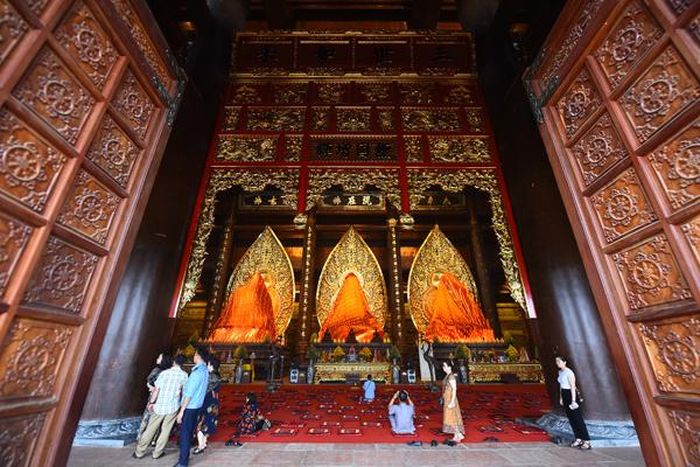 Ba pho tượng Phật bằng đồng dát đồng đen, mỗi bức nặng 200 tấn đặt giữa trung tâm điện Tam Thế.