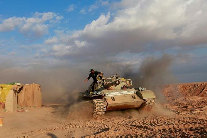 Các tay súng Lực Lượng huy động nhân dân (Popular Mobilization Forces), tổ chức dân quân dòng Shia được Iran tài trợ, trên xe tăng gần biên giới Iraq - Syria ở al-Qaim, Iraq. Ảnh: Reuters. 