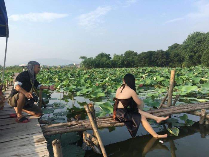 Anh Bùi Trung Kiên nghệ danh “Kiên Nhấp Nháy” đang hướng dẫn khách cách tạo dáng chụp ảnh tại hồ sen