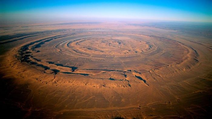  Nếu nhìn từ mặt đất, “the Eye of the Sahara” (Con mắt của Sahara) nằm phía Tây sa mạc Sahara không khác gì những sa mạc khác trên thế giới. Nhưng nhìn từ trên cao, khu vực được xem là điều kỳ diệu của địa chất này thu hút người xem với những hình tròn lồng vào nhau.