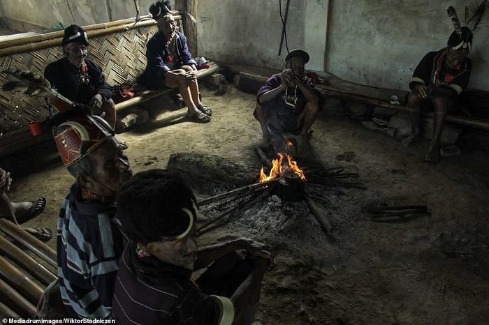 Người Konyak vẫn sống một cuộc đời thô sơ trong những ngôi nhà làm từ tre trúc. Trong ảnh là 7 người già trong bộ lạc đang ngồi quanh một đống lửa.