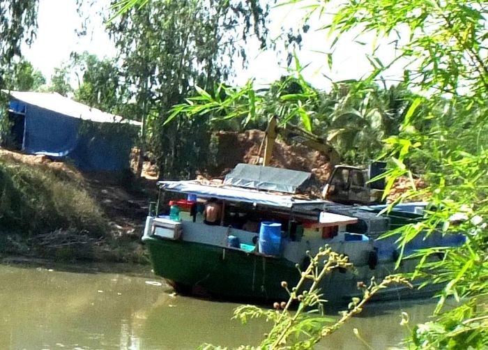 Phương tiện thủy đang chờ đến tài để nhận đất lớp mặt ấp Tân Bảnh, xã Tân Phước, huyện Tân Hồng