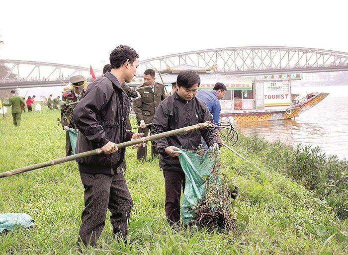 Công an tỉnh Thừa Thiên- Huế cùng sinh viên dọn rác và vớt bèo dọc bờ sông Hương