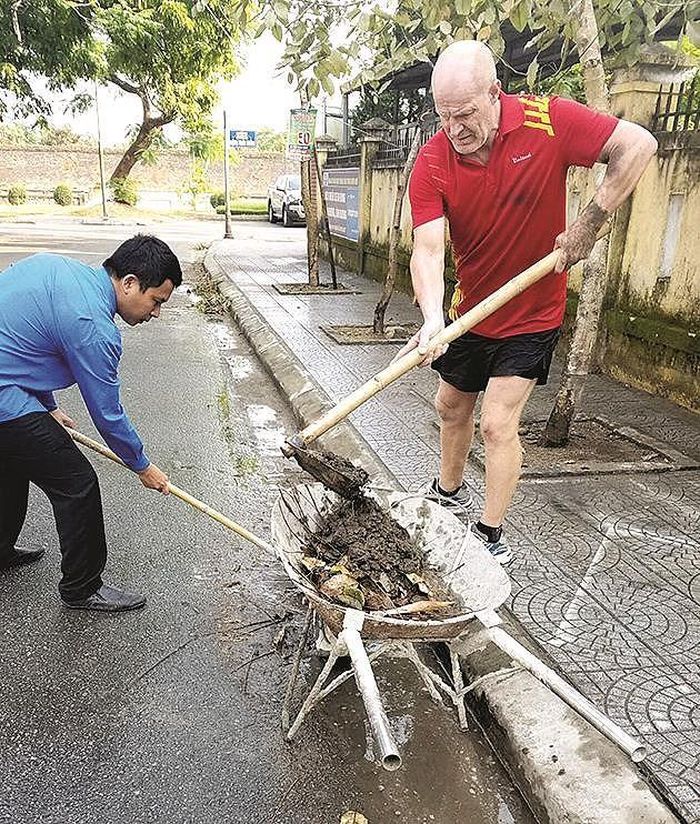 Du khách cùng người dân dọn dẹp bùn đất trên đường phố