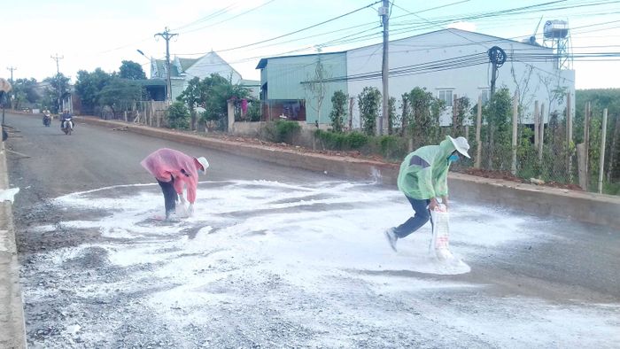 Lực lượng chức năng rải vôi bột trên tuyến đường vào xã Ia Kla. Ảnh Văn Biên