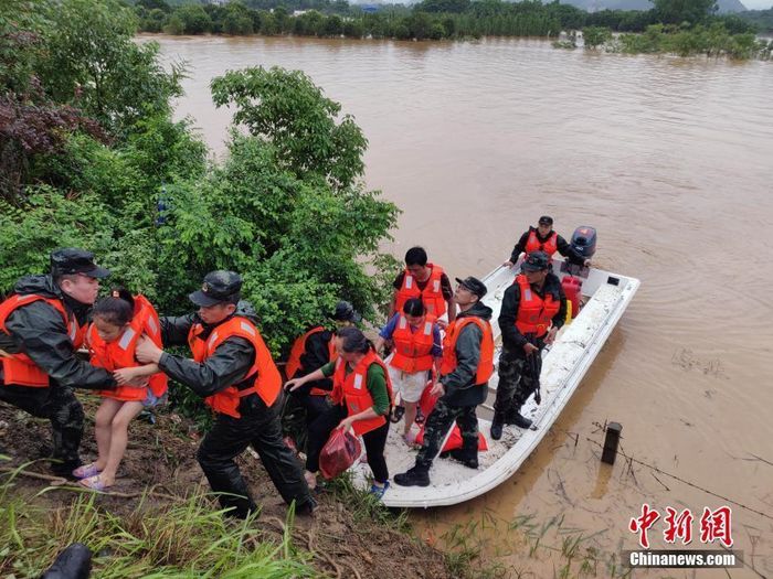 Các sĩ quan cảnh sát vũ trang giải cứu những người bị mắc kẹt trong trận lụt bằng thuyền ở Quảng Tây, Trung Quốc, hôm 9/6. Ảnh: China News.