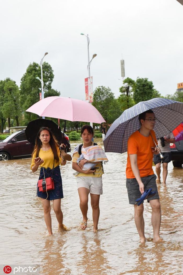 Hành khách lội trong nước ngập ở nhà ga Nam Châu Nam. Lũ lụt đã quét sạch 10.800 ha hoa màu và phá hủy hàng trăm ngôi nhà ở tỉnh Giang Tây hôm 10/6. Ảnh: IC.