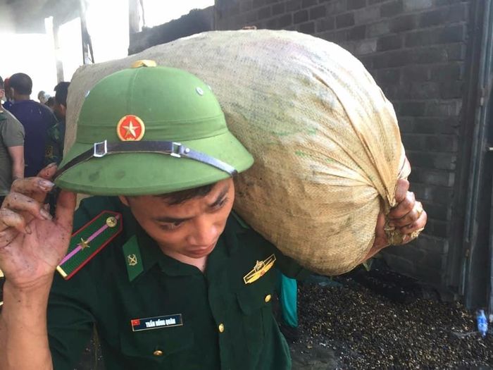 Cán bộ biên phòng giúp người dân di chuyển tài sản ra khỏi đám cháy