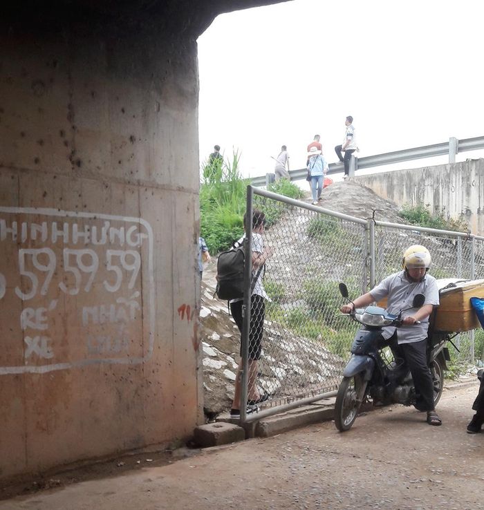 Người dân lách qua hàng rào sắt lên đường cao tốc bắt xe.