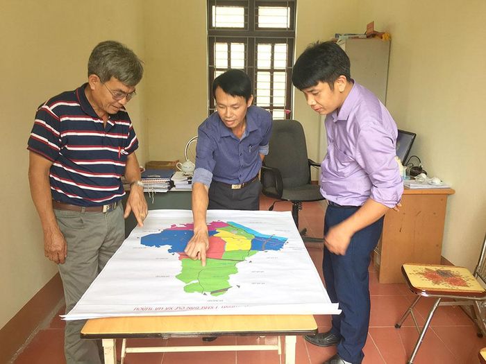 Cán bộ xã Hà Thạch nghiên cứu bản đồ quy hoạch các khu dân cư sau khi sắp xếp, sáp nhập lại.