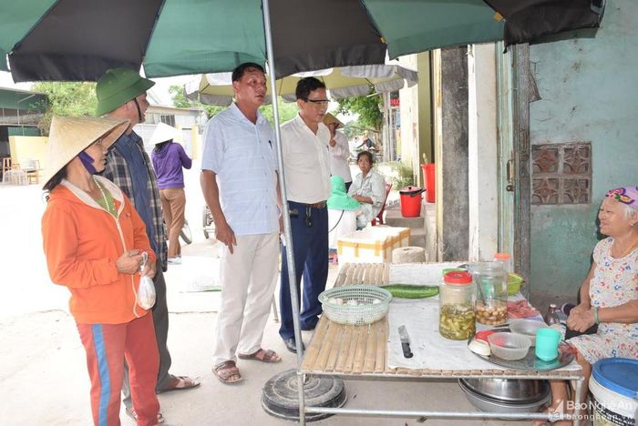 Lãnh đạo huyện Yên Thành và cán bộ xã Hoa Thành đến từng hộ kinh doanh tại khu vực chợ Dinh tuyên truyền tạm thời không kinh doanh buôn bán sản phẩm lợn từ ngày xảy ra dịch đến 30 ngày tới. Ảnh: Xuân Hoàng