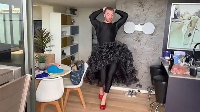 Đi cao gót đỏ, mặc váy đen hoa hồng dập dìu thả dáng catwalk đi như người mẫu trong một clip anh đăng trên mạng