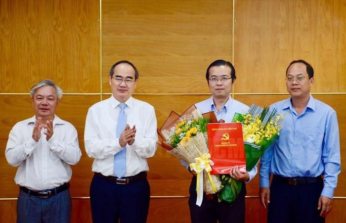 Bí thư Thành ủy TP.HCM Nguyễn Thiện Nhân trao quyết định và tặng hoa chúc mừng ông Lê Văn Minh nhận nhiệm vụ tại Ban Tuyên giáo Thành ủy TP. Ảnh: Long Hồ/ Website Thành ủy TP.HCM
