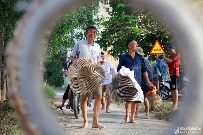 Điểm đặc biệt của hội nơm bàu này là chỉ cho phép người tham gia dùng nơm để bắt cá, tuyệt đối không được sử dụng các công cụ khác. Trên con đường dẫn về Bàu Mực, nô nức khung cảnh người dân mang theo nơm to, nhỏ nhiều kích cỡ để chuẩn bị so tài săn cá. Ảnh: Sách Nguyễn