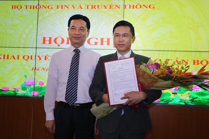 Bộ trưởng TT&TT Nguyễn Mạnh Hùng trao quyết định và tặng hoa chúc mừng cho ông Phạm Anh Tuấn