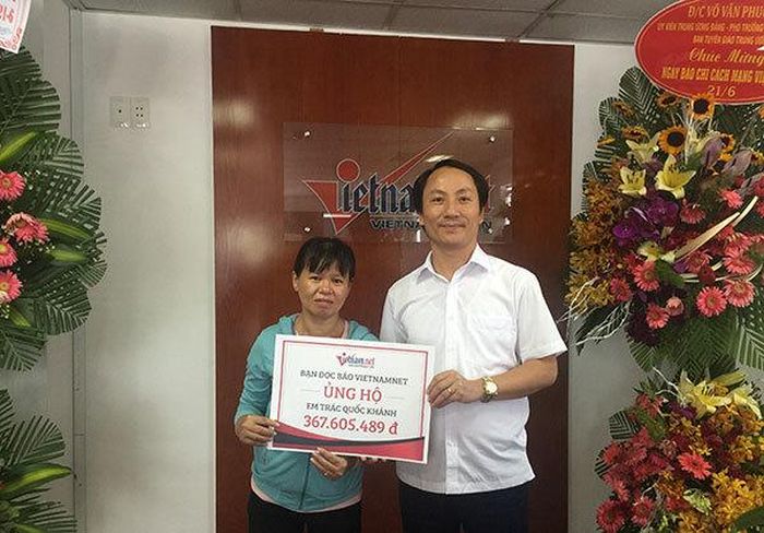 Đại diện Báo VietNamNet trao tiền bạn đọc ủng hộ cho mẹ bé Nguyễn Quốc Khánh